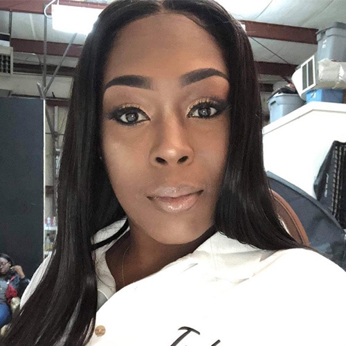 Portrait of a Black Lady Smiling at the Camera wearing a white professional shirt. Tashawna