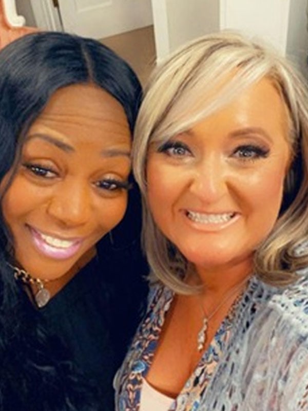 Selfie of Smiling African-American Lady and White Lady looking into the camera