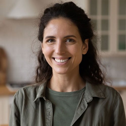 Portrait of Smiling Hispanic Lady wearing a green t-shirt and green duster looking hopeful